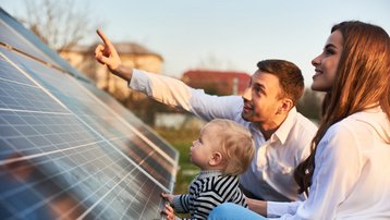 Photovoltaik bei der Hausplanung frühzeitig mitdenken Familie informiert sich gemeinsam über Photovoltaikmodule für ein energieeffizientes Zuhause